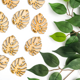 Monstera shaped wooden leaves beside green pothos leaves