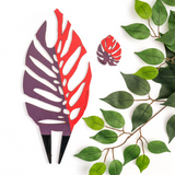 purple and red colored Monstrella trellis with a little leaf cut out with the same color