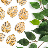 monstera leaf shaped wooden cut outs with baby bare by Treleaf engraved on it